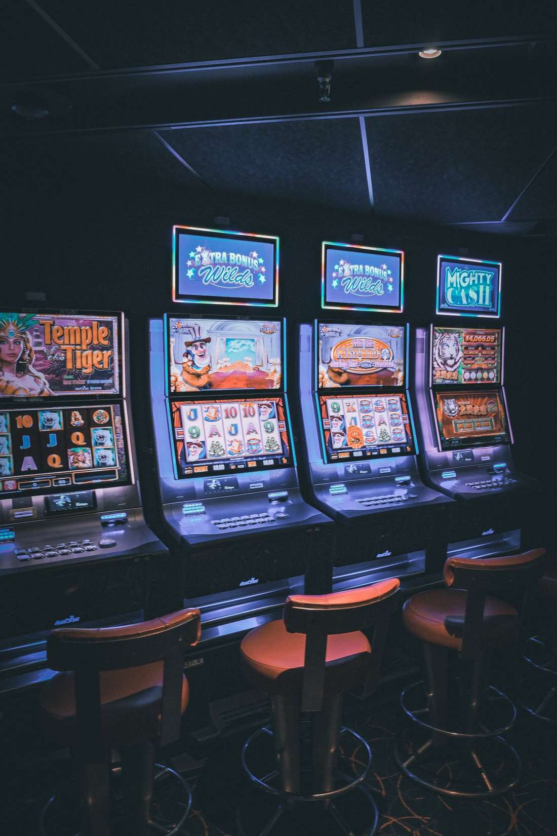 Deretan mesin slot menyala berjajar di ruang permainan
